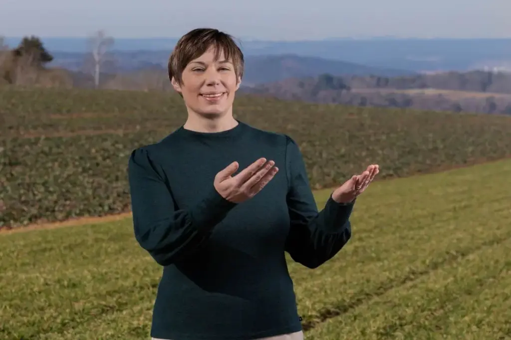 Dorothee Hildbrand steht selbstbewusst im Feld, mit offenen Händen nach vorn gerichtet – Symbol für neue Perspektiven und den Weg zu innerer Ruhe trotz Gedankenchaos.